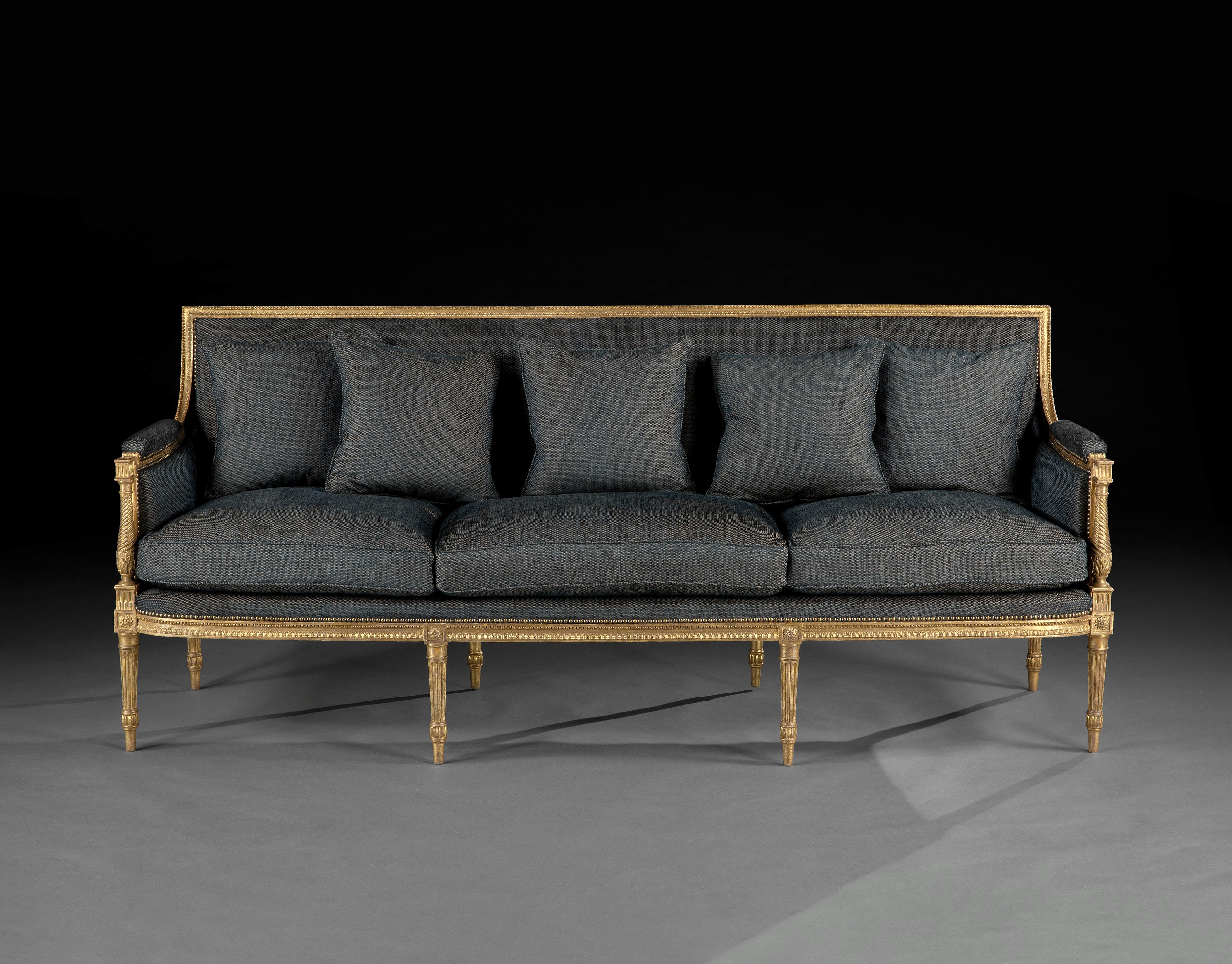 A rare suite of giltwood furniture, comprising a pair of armchairs and a long sofa
